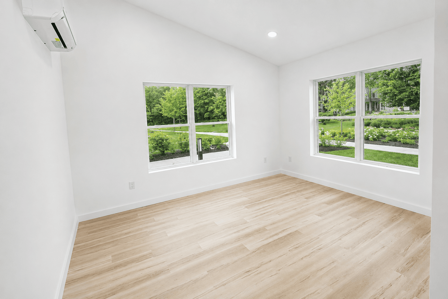 Unfurnished Tillson Woods bedroom with light wood-tone flooring and windows.